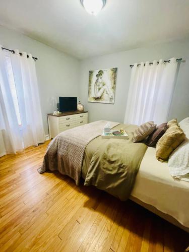 a bedroom with a large bed and a wooden floor at Come home to Kenwood Conveniently located Syracuse in Syracuse