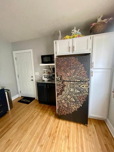 a kitchen with a black refrigerator with a painting on it at Come home to Kenwood Conveniently located Syracuse in Syracuse