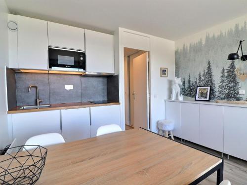 une cuisine et une salle à manger avec une table et des chaises dans l'établissement Charmant 2P rénové, accès skis aux pieds, Méribel - FR-1-182-238, à Les Allues