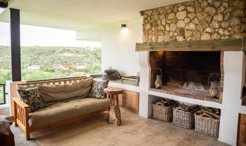 a living room with a couch and a fireplace at Oudewerfskloof Olive Farm in Stilbaai