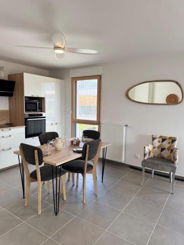 une cuisine et une salle à manger avec une table et des chaises dans l'établissement Le Doublaix - Superbe T3 neuf - Parking privé -, à Aix-les-Bains
