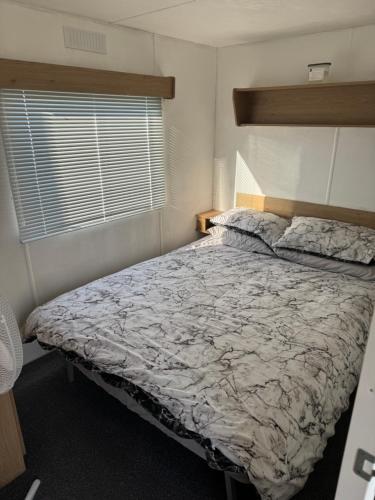 a bedroom with a large bed in a room at Seawick Holiday Park Caravan Hire in Saint Osyth
