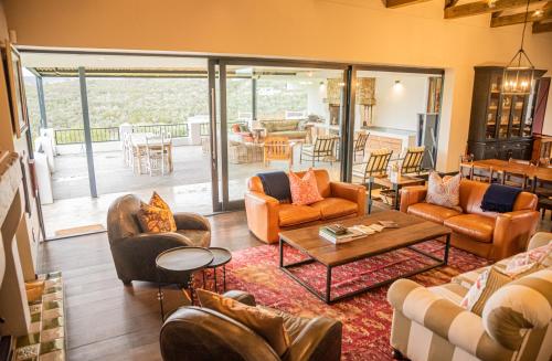 a living room with couches and chairs at Oudewerfskloof Olive Farm in Stilbaai