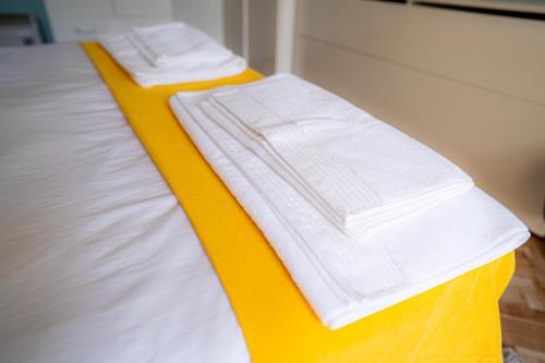 two white towels are sitting on a bed at Claire Apartment with Garden in Sofia
