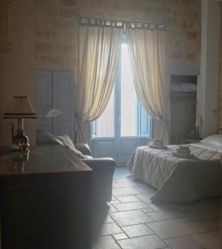 a bedroom with two beds and a large window at Bed & Breakfast Casa Lopez in Barletta