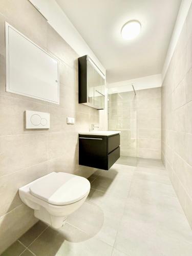 a white bathroom with a toilet and a sink at Apartment mit Balkon und Parkplatz in Vienna