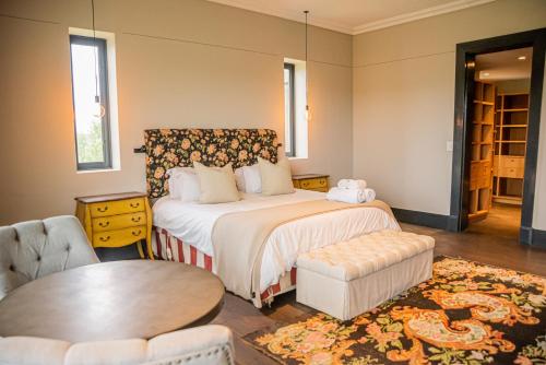 a bedroom with a bed and a table and chairs at Oudewerfskloof Olive Farm in Stilbaai