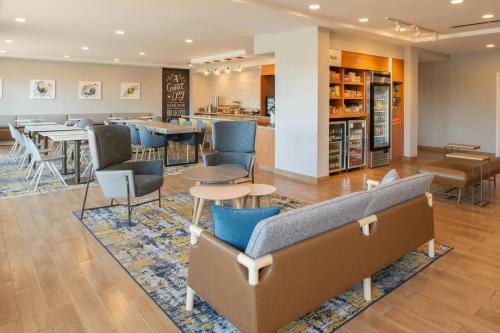 a lobby with chairs and tables and a bar at TownePlace Suites by Marriott Jackson Ridgeland/The Township at Colony Park in Ridgeland