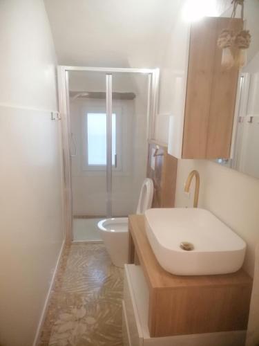 a white bathroom with a sink and a toilet at Allegra22 in Sale Marasino