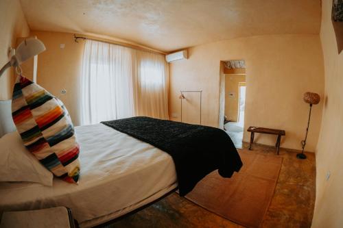 a bedroom with a bed with a black blanket at Casa de São Roque in Avis