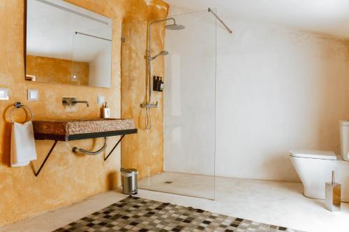 a bathroom with a glass shower and a sink at Casa de São Roque in Avis