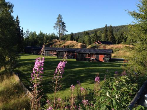 a house on a hill with purple flowers in the foreground at Trysil Hyttegrend in Trysil