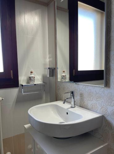 a white bathroom with a sink and a mirror at Il Ghiandolino in Imola