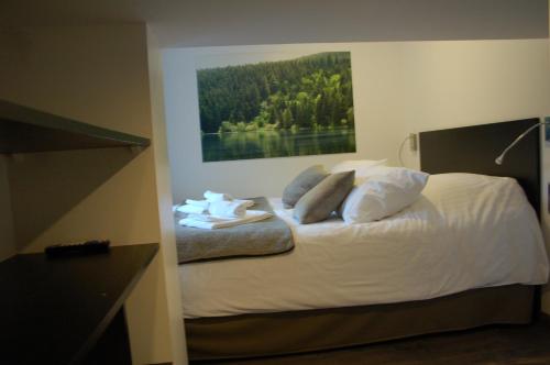 a bedroom with a bed with white sheets and pillows at Aux 500 Diables Eco Lodge - Hotel in Chambon-sur-Lac