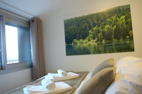 a bedroom with a bed and a window with towels at Aux 500 Diables Eco Lodge - Hotel in Chambon-sur-Lac