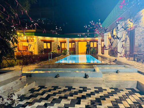 a swimming pool in front of a house at night at Kandahena Mansion in Akuressa