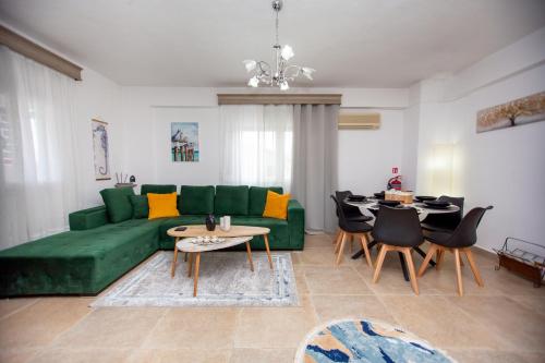 a living room with a green couch and a table at LUNA'S HOUSE in Asprovalta
