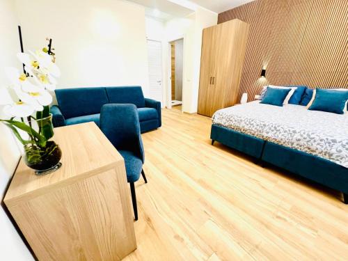 a living room with a bed and a blue couch at Casa Romano SeaFront in Fiumicino