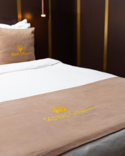 a close up of a bed with a hotel sign on it at Hotel Opera in Pristina