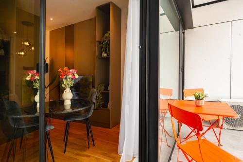 Exclusive 1BR Apartments in ONE Cotroceni في بوخارست: غرفة طعام ومطبخ مع طاولة وكراسي