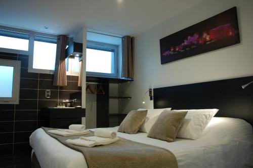 a bedroom with a bed with two towels on it at Aux 500 Diables Eco Lodge - Hotel in Chambon-sur-Lac