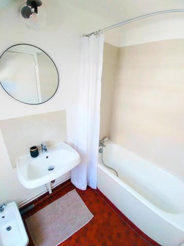 une salle de bain avec un lavabo, une baignoire et un miroir dans l'établissement Best of Chartres one bedroom city center and view on the Cathedral, à Chartres