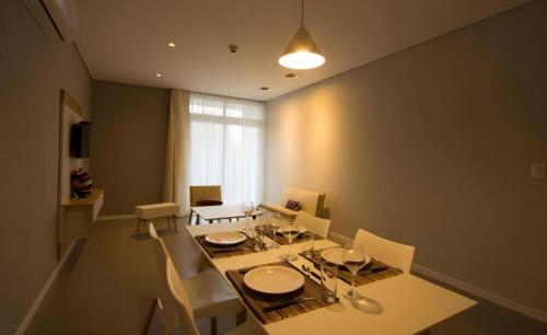 a dining room with a table and chairs and a window at Tapu'a Departamentos in Asuncion
