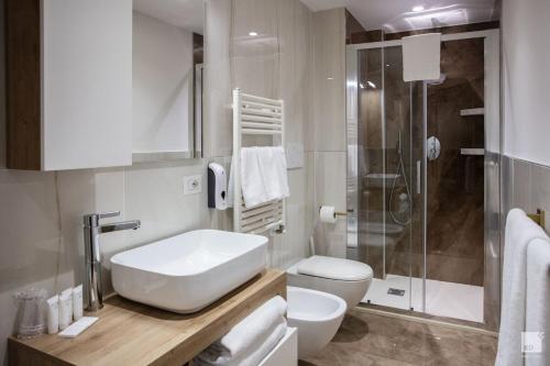 a bathroom with a sink and a toilet and a shower at Design Suite in Historical Palace in Bologna