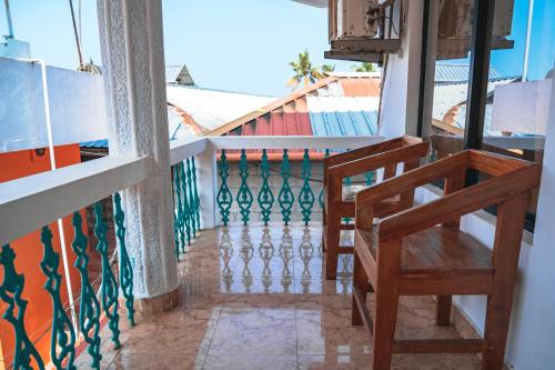 a balcony with two chairs and a view of a building at Cliff and Coral Varkala, North Cliff in Varkala