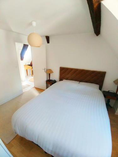 une chambre avec un grand lit blanc dans une pièce dans l'établissement Best of Chartres one bedroom city center and view on the Cathedral, à Chartres