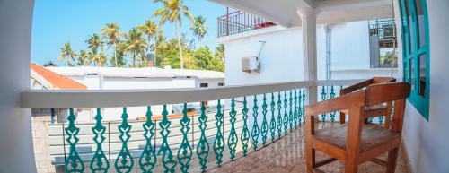 a balcony with a chair and a view of a pool at Cliff and Coral Varkala, North Cliff in Varkala