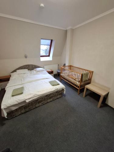 a bedroom with a large bed and a crib at AMRI Apartman in Balatonföldvár