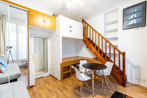 - un salon avec un escalier, une table et des chaises dans l'établissement GuestReady - Lovely home near Notre-Dame Cathedral, à Paris