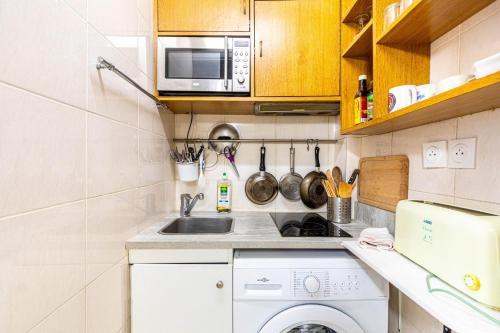 Il comprend une petite cuisine équipée d'un lave-linge et d'un four micro-ondes. dans l'établissement GuestReady - Lovely home near Notre-Dame Cathedral, à Paris