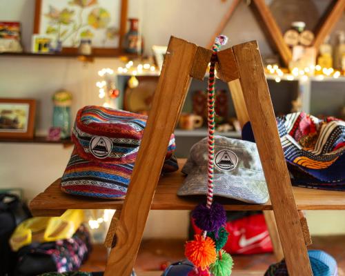 a group of knitted bags on a wooden shelf at Casa Marimba in La Laguna