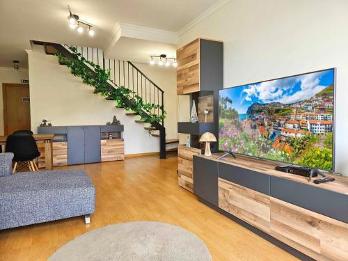 a living room with a large flat screen tv at A SELVA T2 in Caniço in Caniço