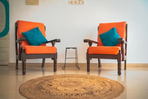 two orange chairs with blue pillows in a room at Cliff and Coral Varkala, North Cliff in Varkala