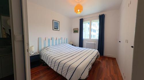 une chambre avec un lit avec une couverture rayée dans l'établissement Appartement vue mer, 4 pers - idéal famille, à La Baule