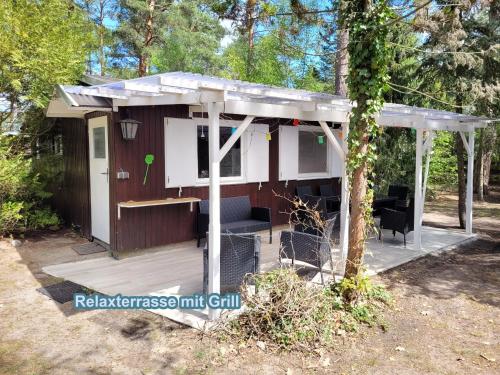 a chicken coop with a roof on a deck at Hüttendorf für Euch alleine - geführter Yachtausflug nach Prieros inclusive! Nur 3 Minuten zum Badesee Fahrräder kostenlos vorhanden in Groß Köris