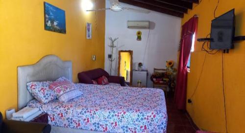 a bedroom with a bed and a yellow wall at Hospedaje Luque in Luque