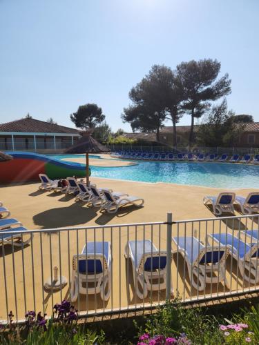 une piscine avec des chaises longues et une piscine dans l'établissement Maison de vacance toute équipée, à Calvisson