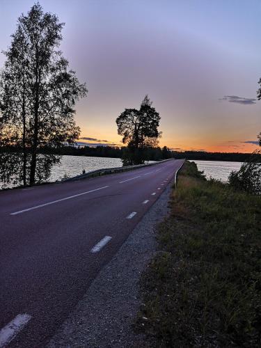 an empty road next to a body of water at Djurstagården Hälsingegård in Jättendal