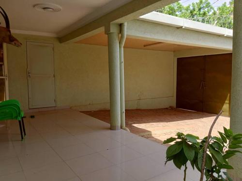 an empty house with a porch with columns and a door at Villa Z in Ouagadougou