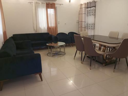 a living room with a couch and a table and chairs at Villa Z in Ouagadougou