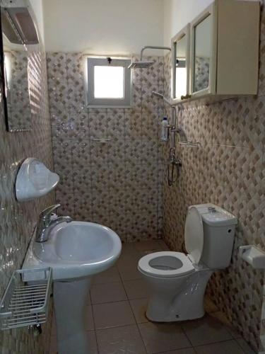 a bathroom with a toilet and a sink at Villa Z in Ouagadougou