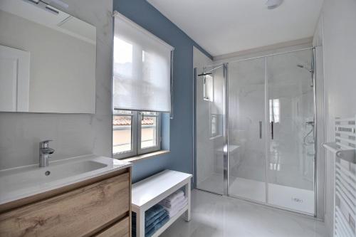 ブールジュにあるLa Suite Marcel Bascoulard - Charme et Histoireの洗面台とガラスのシャワーを備えたバスルーム