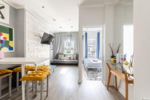 a white living room with a table and chairs at Stylish flat in West Hampstead in London