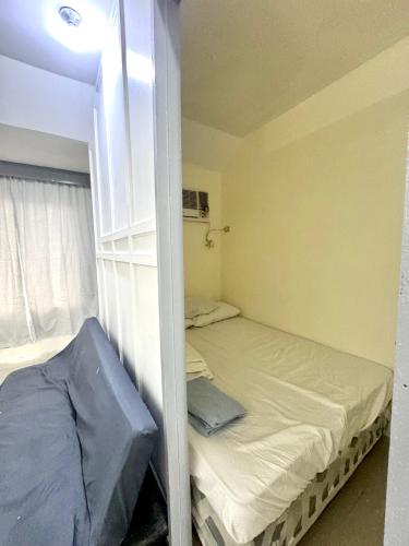 a small room with a bed and a window at ACE Condo in Cebu City