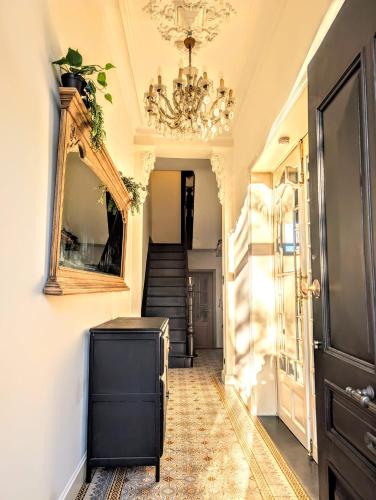 a hallway with a mirror and a chandelier at 't Herenhoes in Neerpelt