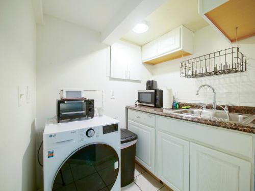 a kitchen with a washing machine and a sink at Cozy Studio Unit Close to New York City in Jersey City